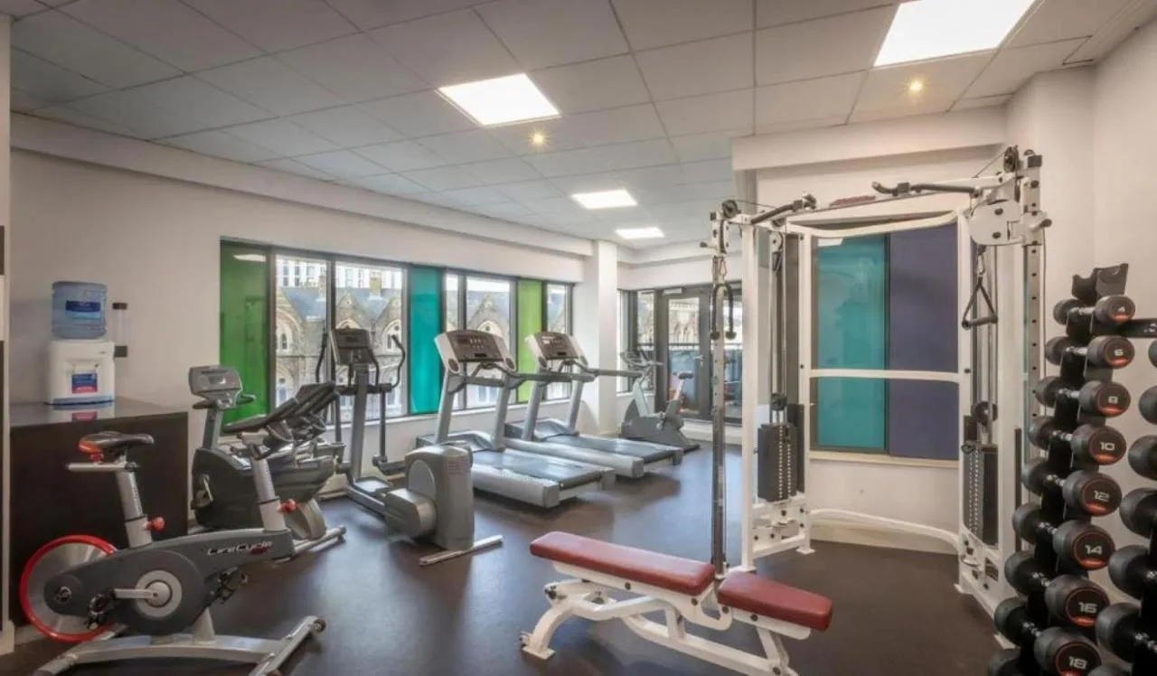 a gym with several tread machines in a room at Clayton Hotel Cardiff in Cardiff